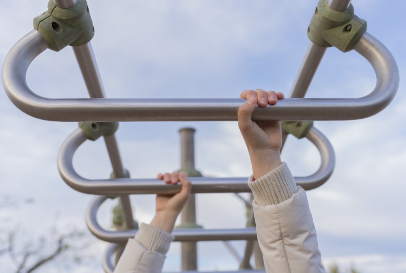 Handen aan een klimrek in een buitenfitness