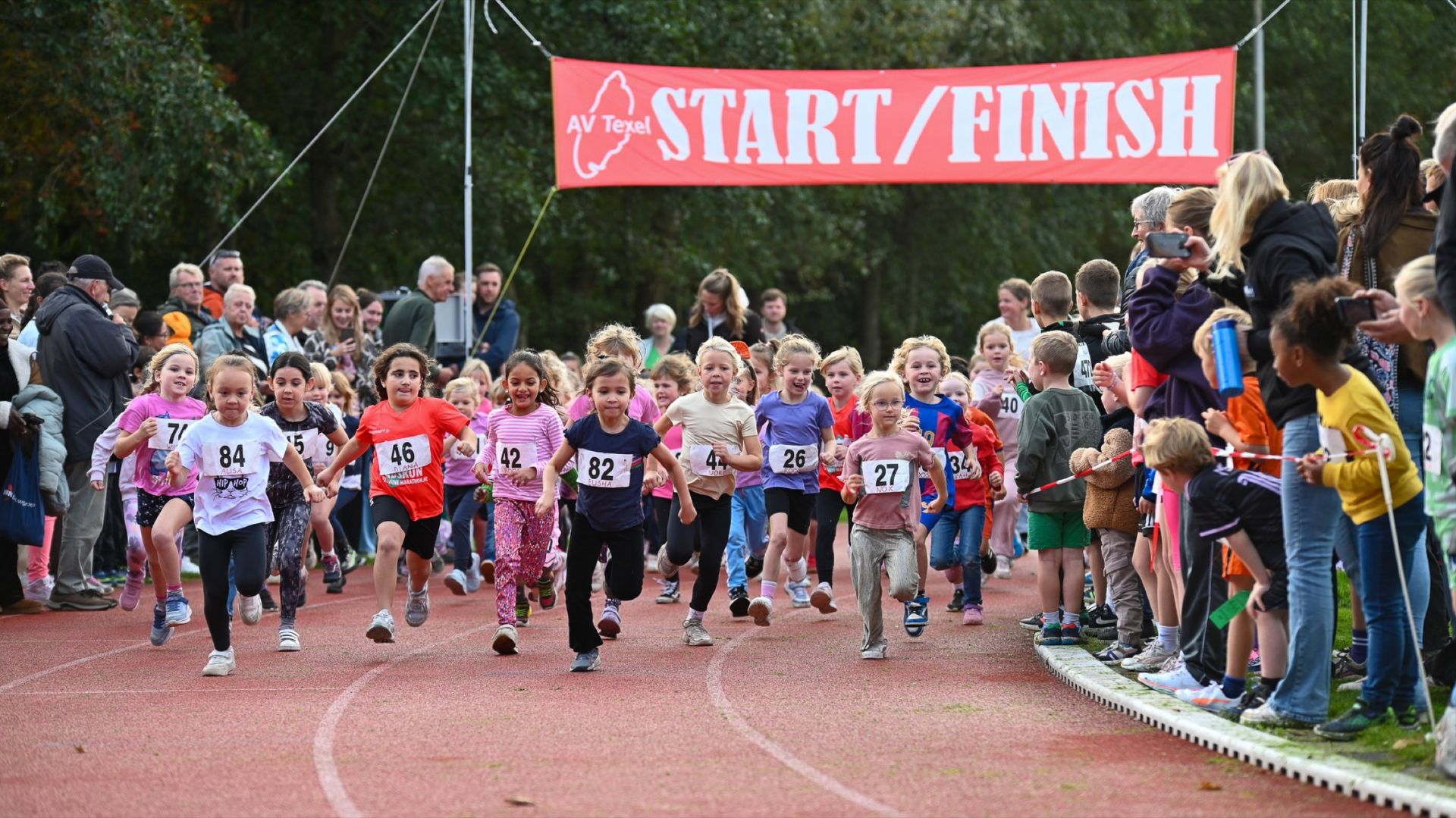 Kinderen lopen hard bij de start van een hardloopwedstrijd