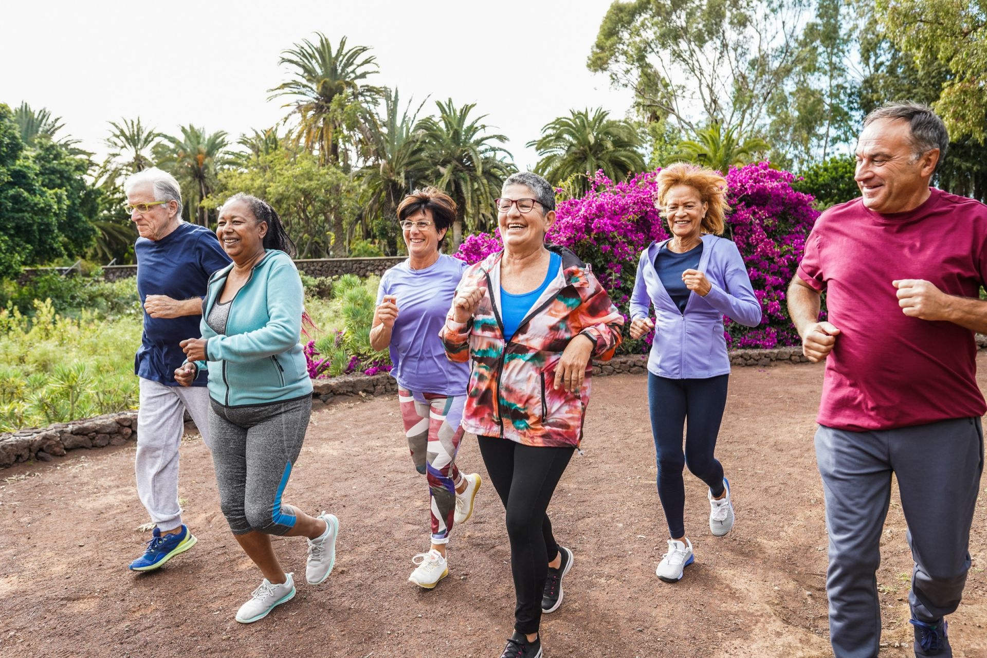 Groep vrouwen wandelt in een tuin vol bloemen