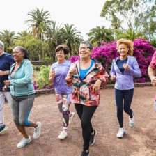 Groep vrouwen wandelt in een tuin vol bloemen