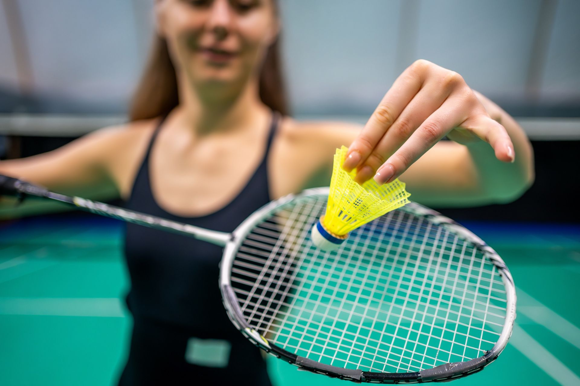 Badmintonspeelster houdt een shuttle en racket vast
