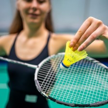 Badmintonspeelster houdt een shuttle en racket vast