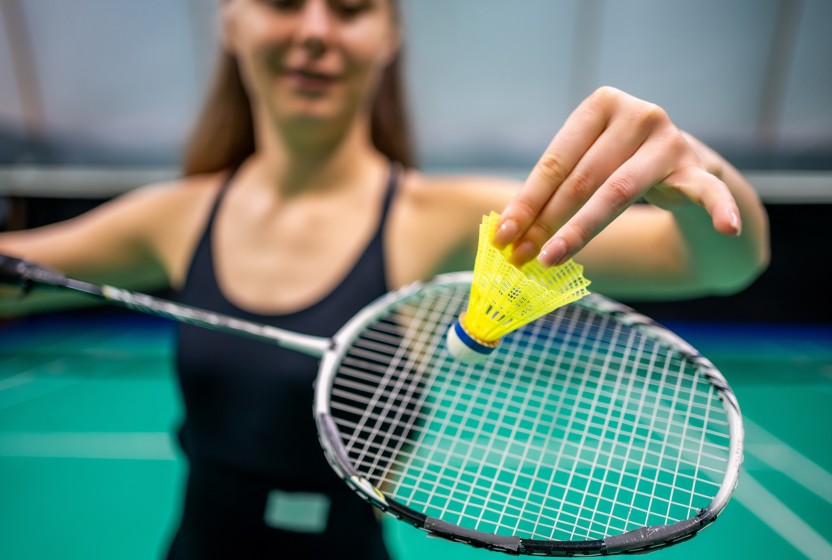 Badmintonspeelster houdt een shuttle en racket vast
