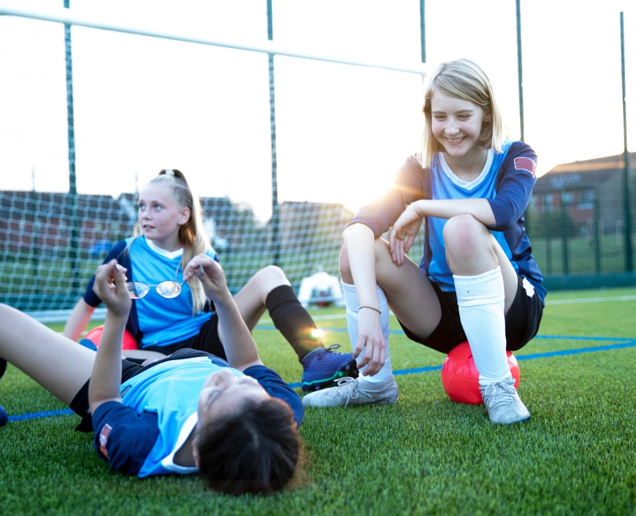 Kinderen spelen voetbal op een kunstgrasveld