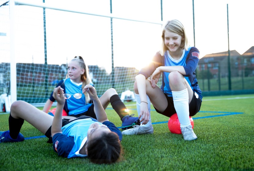 Kinderen spelen voetbal op een kunstgrasveld